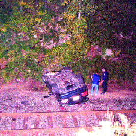 Car Lands on Railroad Tracks